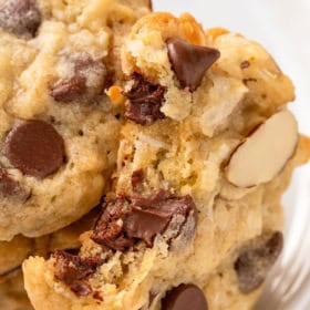 Coconut chocolate chip cookies with almonds on a small white plate.
