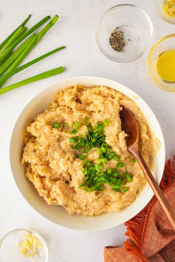 These sweet and savory Asian Chicken Meatballs are infused with fresh ginger and garlic, then baked and coated in a sticky honey-soy glaze. The raw meatball mixture is in a white bowl.