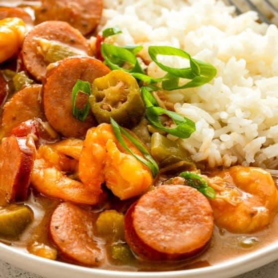 A hearty portion of seafood gumbo served with fluffy white rice.
