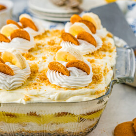 Banana pudding in a glass baking dish, viewed from the side to show the layers.