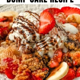 A plate of banana split dump cake topped with vanilla ice cream, chocolate drizzle, whipped cream, strawberries, and banana slices.