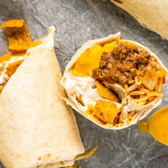 An overhead shot of burritos on a tray. One burrito has been sliced in half diagonally and half is standing on its end.