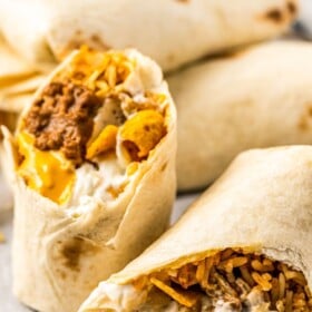 Taco Bell Beefy Melt Burrito sliced in half on a tray.