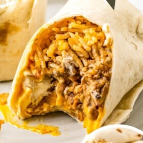 A bite taken out of a Beefy Melt Burrito.