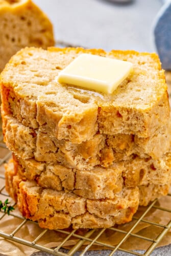 Slices of bread stacked on top of each other showing the edges of the crisp and crackly crust this beer bread recipe creates.