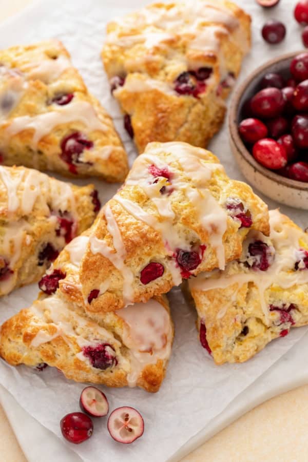 Perfectly dense and flaky, these Cranberry Orange Scones are filled with tart cranberries & fresh orange zest. Easy to make in under an hour! A small pile of the best cranberry orange scones.