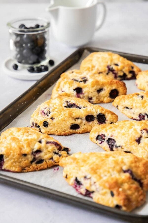 These Blueberry Scones are soft, flaky and bursting with blueberries. Add a creamy vanilla glaze and this easy scone recipe is a real treat! Blueberry scones fresh out of the oven