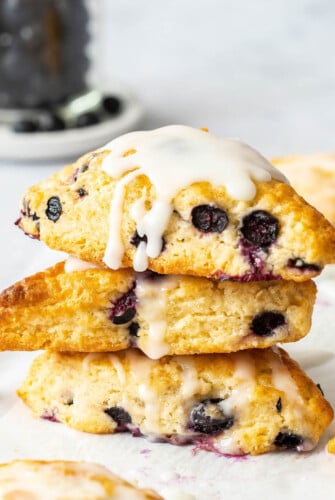 A stack of three blueberry scones drizzled with vanilla glaze