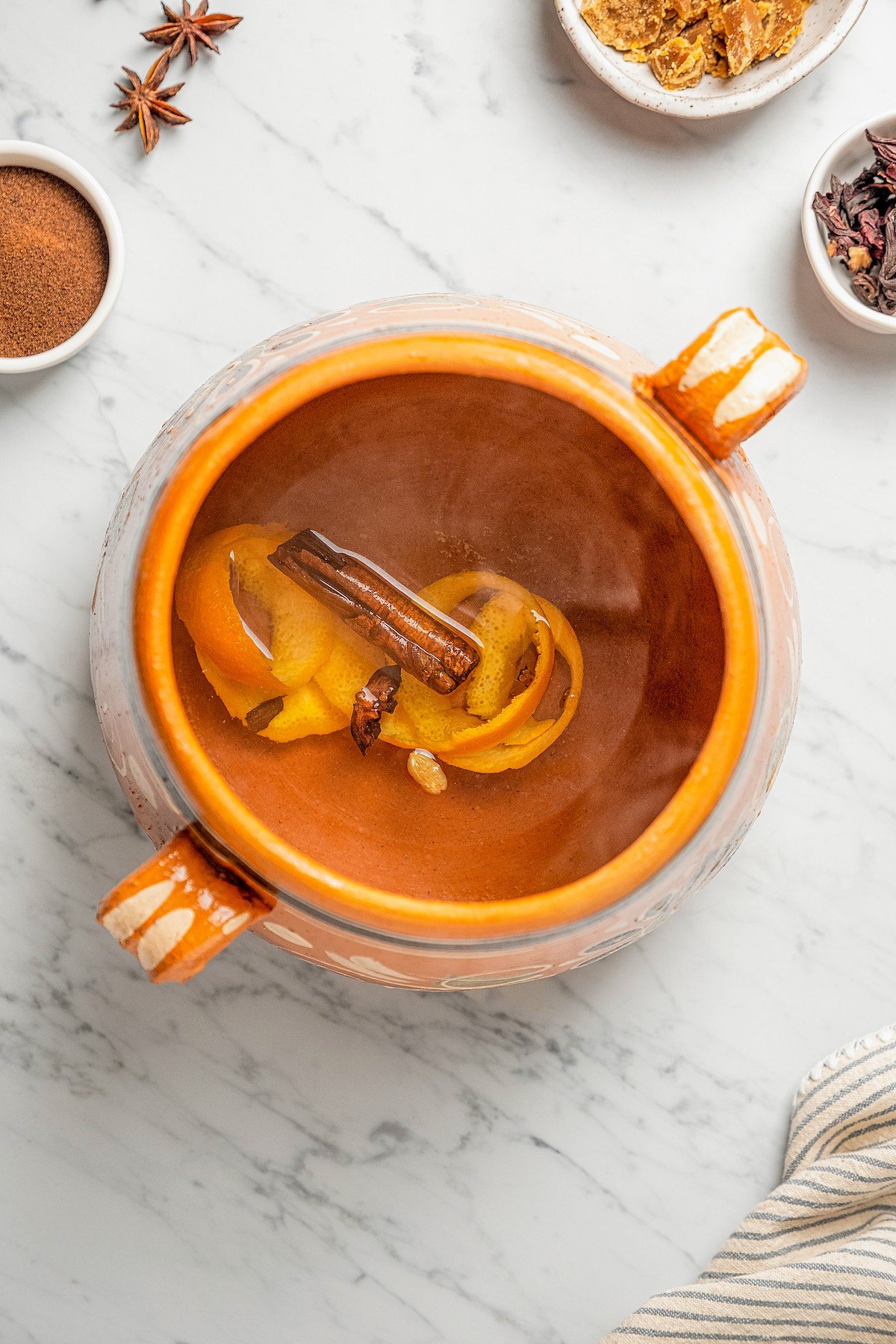 Full of warm spices and piloncillo, this comforting Café de Olla is an authentic Mexican Coffee recipe to warm you up on a cold morning. A pot of water with cinnamon, dried hibiscus flowers, cardamom, star anise, cloves and orange peel to create Cinnamon Mexican Coffee.