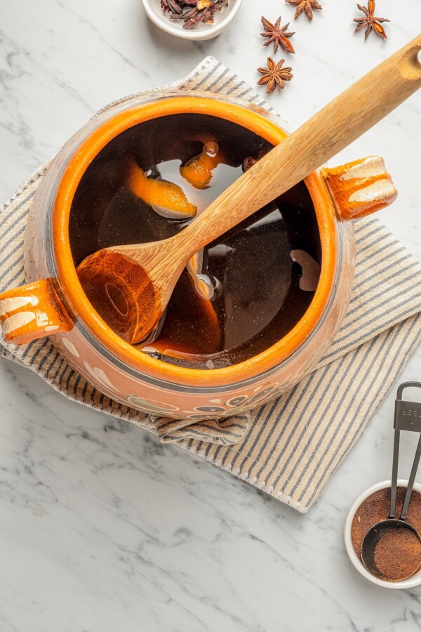 Full of warm spices and piloncillo, this comforting Café de Olla is an authentic Mexican Coffee recipe to warm you up on a cold morning. A pot of Café de Olla being stirred with a wooden spoon.