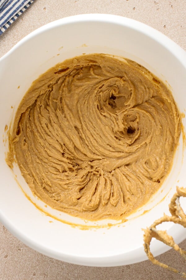 The BEST chewy peanut butter cookies with soft chewy centers, crispy edges and tons of peanut butter flavor! Easy recipe ready in 30 minutes! Peanut butter, butter, brown sugar and granulated sugar being beaten together with a hand mixer.