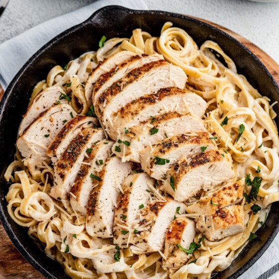 Overhead shot of a cast-iron skillet with pasta and chicken.
