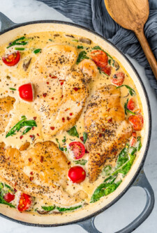 A skillet of Chicken Florentine with fresh cherry tomatoes.