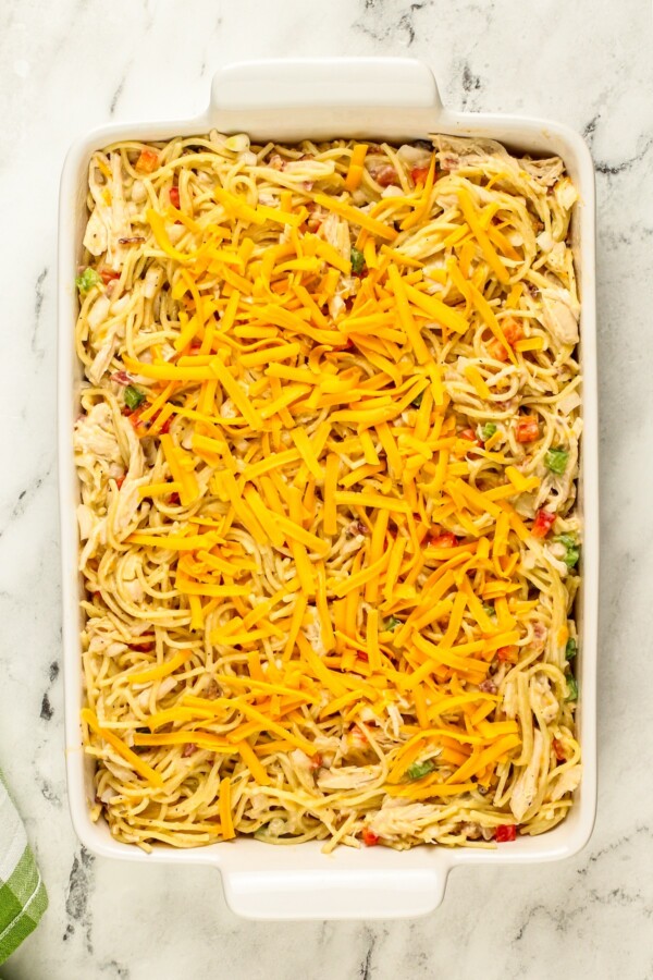 This Chicken Spaghetti recipe is quick, easy, and loaded with flavor. The secret? It's loaded with bacon and a delicious creamy cheese sauce! An uncooked pasta bake is topped with shredded cheddar cheese.