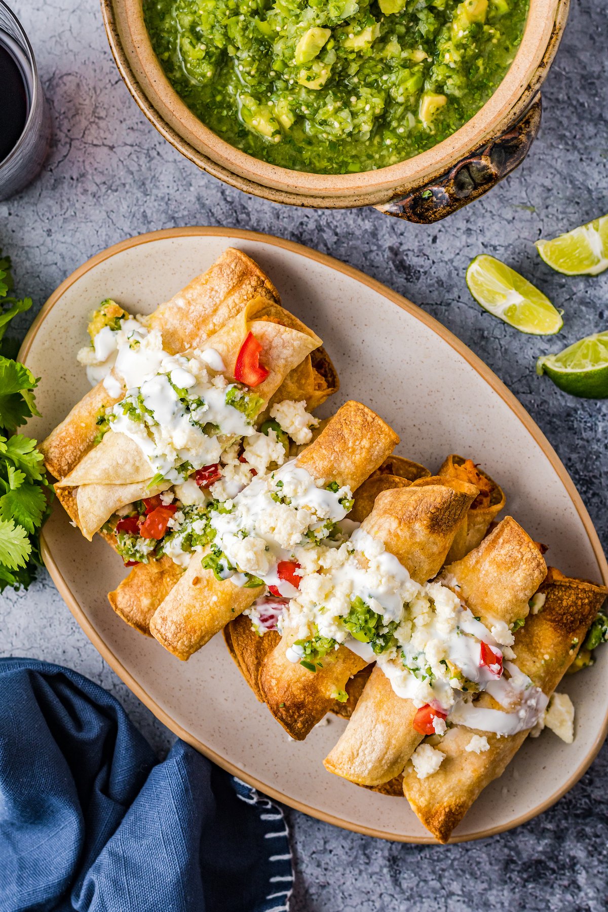 Overhead shot of a plate of fried tortilla roll ups.