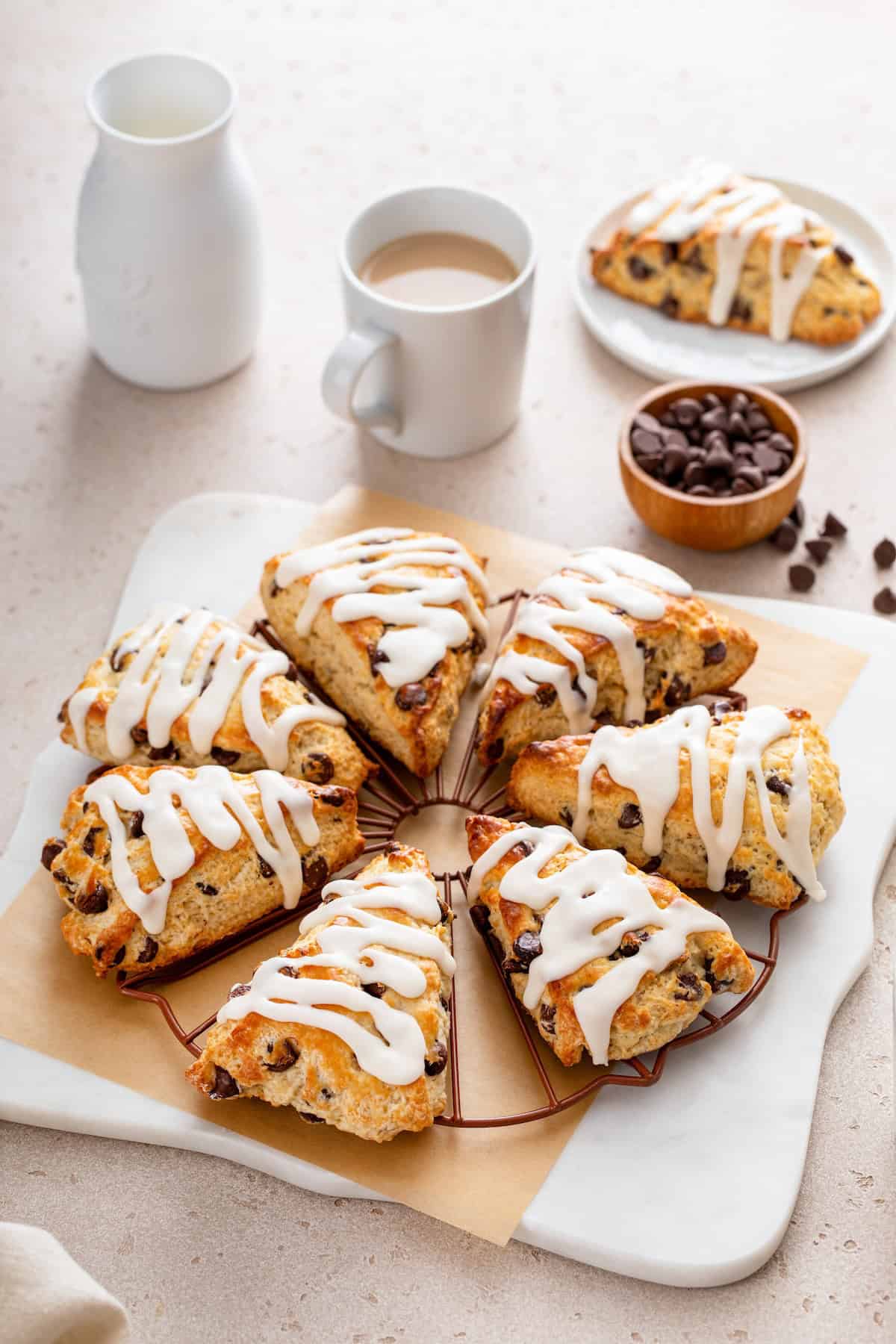 Made with simple ingredients, these Chocolate Chip Scones are perfectly flaky, soft, and buttery, with lots of melty chocolate chips! Homemade chocolate chip scones are topped with icing and placed in a neat circle.
