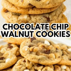 A stack of chocolate chip walnut cookies, featuring both white and dark chocolate chips, with more cookies spread out below.
