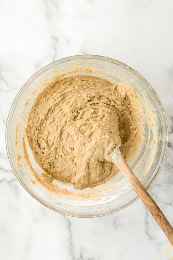 Donut hole batter is being mixed in a glass bowl.