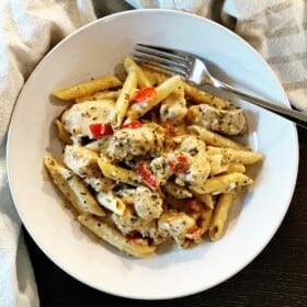A bowl of creamy Cajun chicken pasta with a fork on the side.