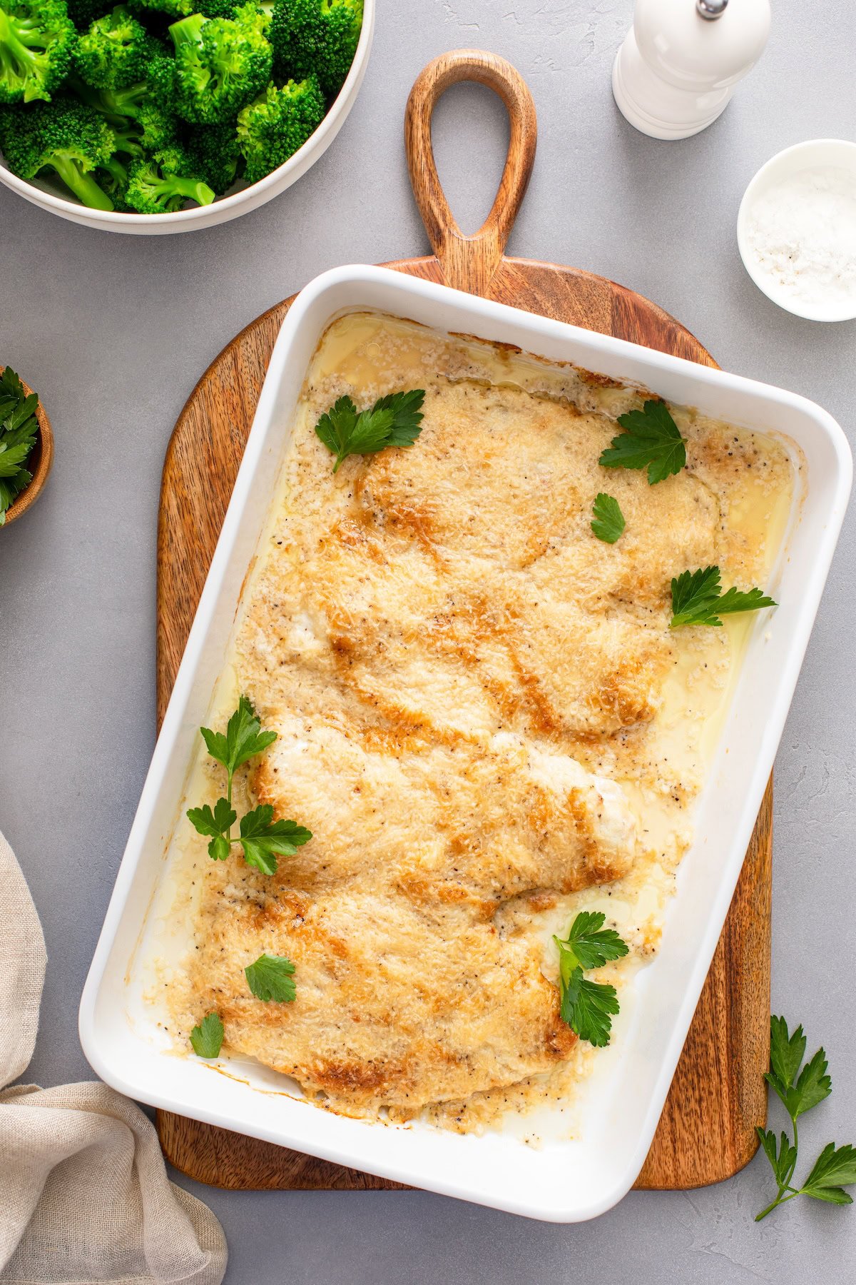 This creamy Garlic Parmesan Chicken recipe is a low-carb dinner that is packed with flavor, but made easy with just 4 simple ingredients! Baked garlic parmesan chicken breasts are garnished with fresh parsley.