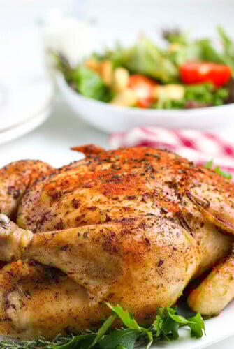 Juicy crockpot whole chicken with crispy skin on a serving platter.