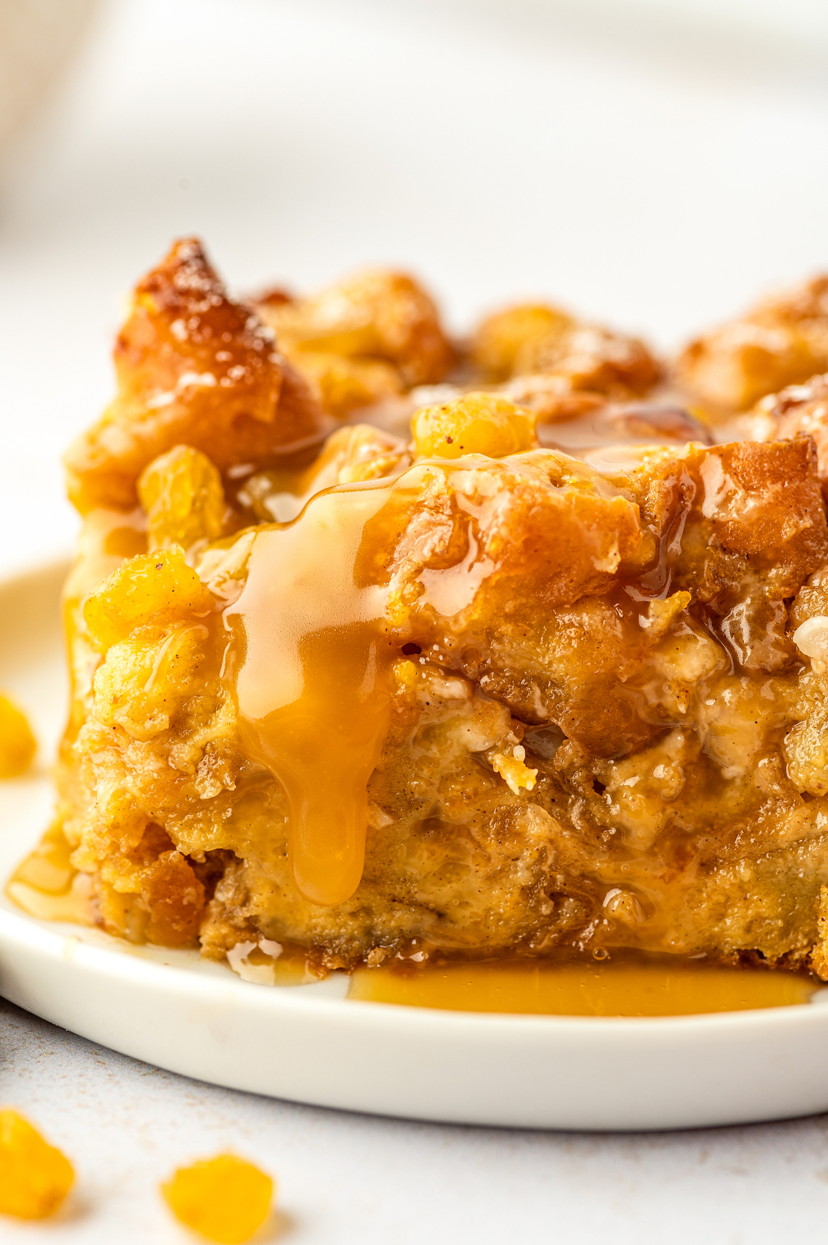 This warm and fluffy donut bread pudding with sweet raisins and buttery rum sauce is an impressive, but easy dessert you can prep ahead! Rum sauce on the donut bread pudding.