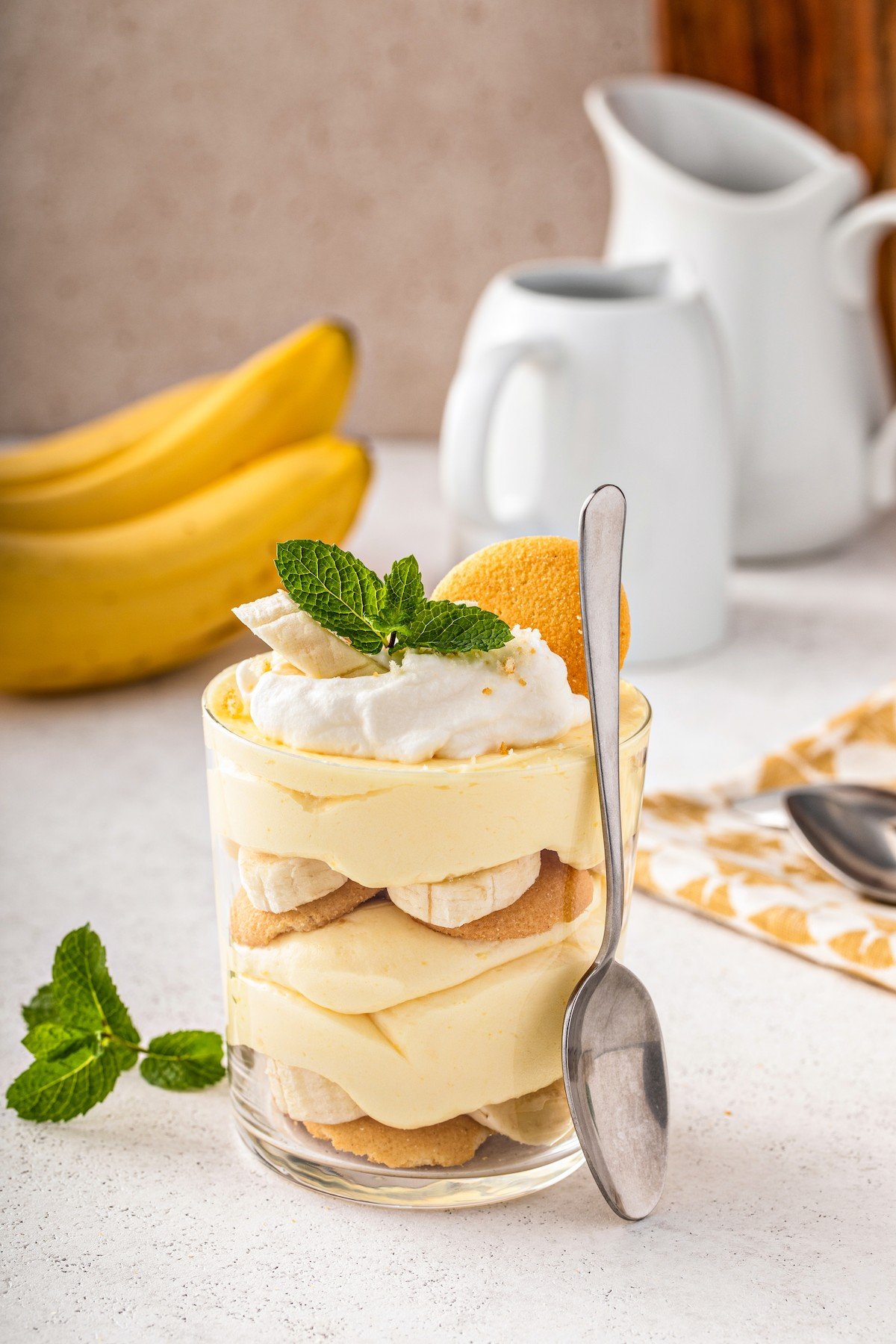 This easy banana pudding recipe has layers of fresh bananas, creamy pudding, vanilla wafers & whipped cream. The best banana pudding ever! A personal homemade banana pudding with a spoon leaning against the dish