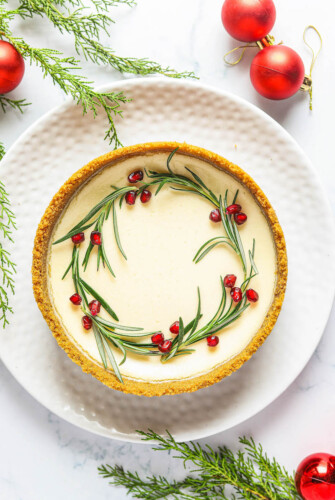 Eggnog cheesecake with pomegranates and rosemary.