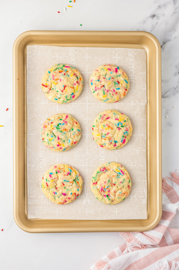 These cute, colorful Funfetti Cookies are soft, sweet, and simple to make. One cheerful sprinkle cookie just isn’t enough! A baking sheet with six baked funfetti cookies on it.