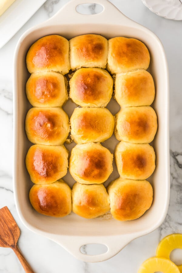 Soft & buttery Hawaiian Rolls are golden in color with a sweet hint of pineapple flavor. This homemade yeast roll recipe is a crowd favorite! Baked soft yeast rolls in a baking dish.