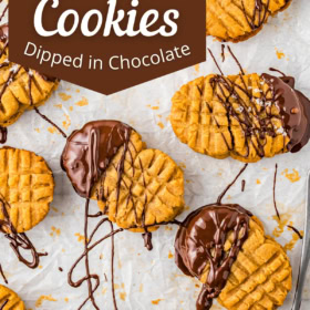 Homemade Nutter Butter Cookies with fluffy peanut butter filling and a topping of chocolate and sea salt on parchment paper.