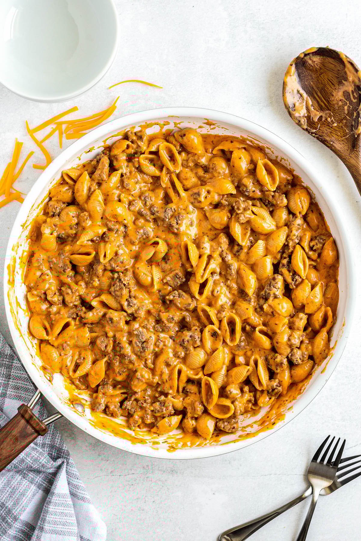Ready in 30 minutes, this Homemade Hamburger Helper recipe is made with heavy cream and real cheddar cheese for an ultra-creamy sauce! A skillet filled with cheesy homemade hamburger helper with ground beef and tender noodles coated in a creamy sauce.