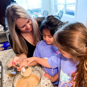 A mom and daughters making muffins.