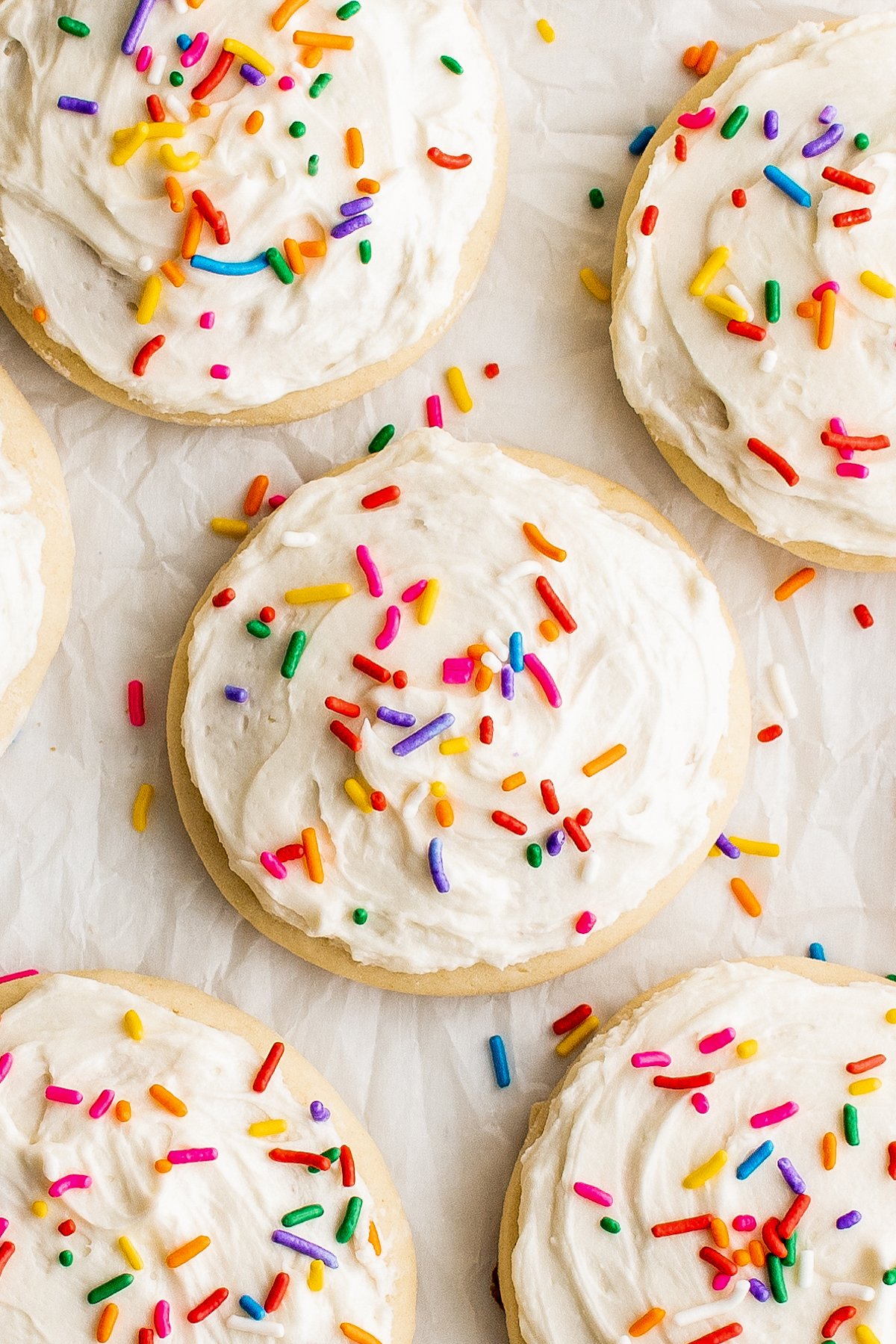This copycat recipe for melt-in-your-mouth Lofthouse Cookies with homemade frosting are soft, thick and topped with fun sprinkles! Close-up shot of frosted sugar cookies decorated with sprinkles.