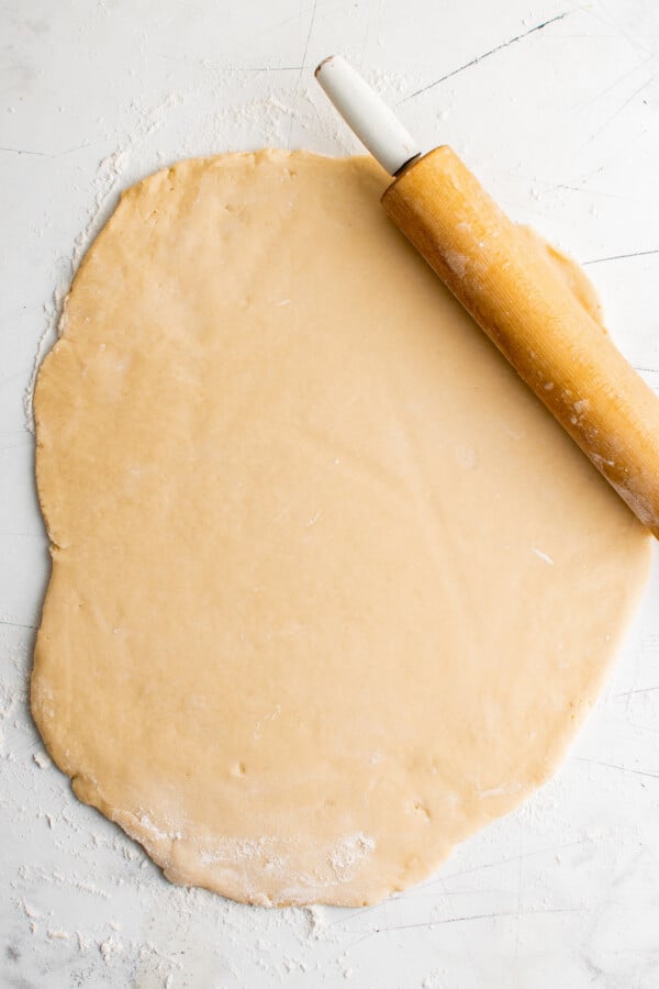 Rolled-out sugar cookie dough on a work surface.