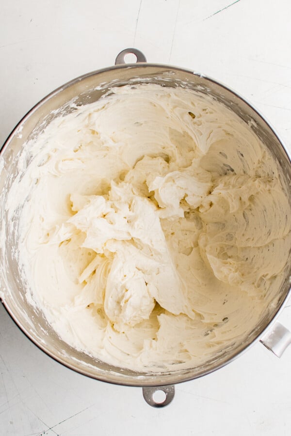 Beaten frosting in a metal mixing bowl.