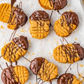 Nutter butter cookies on parchment paper dipped in chocolate with sea salt.