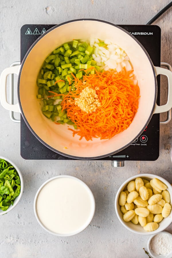 Celery, shredded carrots, and onion in a Dutch oven.
