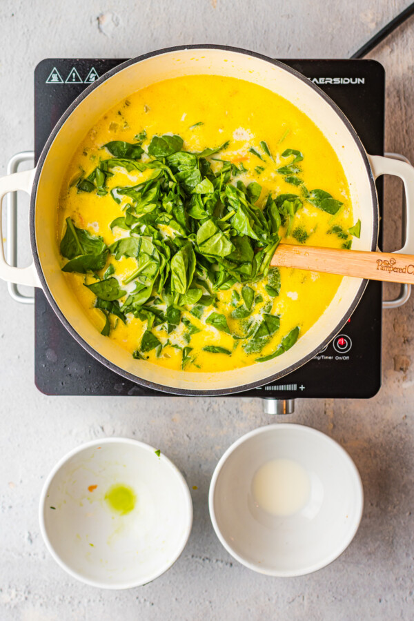 Fresh spinach stirred into chicken soup.