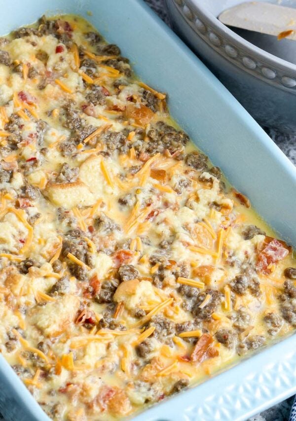 A white casserole dish with an uncooked casserole ready to bake