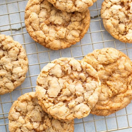Seven peanut butter oatmeal cookies heaped on a baking rack.