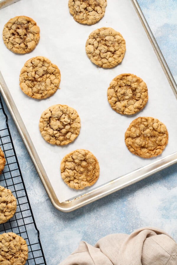 With a hint of cinnamon, crisp edges, and a chewy center, these wholesome Peanut Butter Oatmeal Cookies are sure to please! Baked peanut butter oatmeal cookies on a cookie sheet.