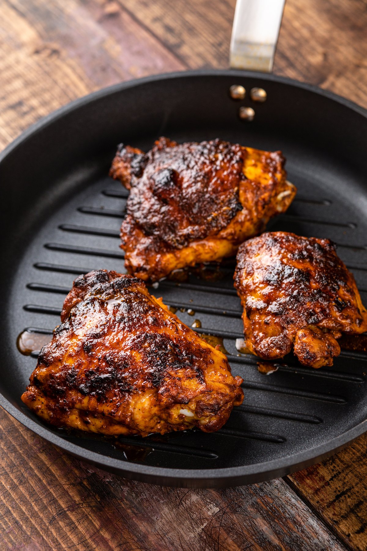 This juicy Mexican pollo asado is tangy, sweet, and smoky. Loaded with orange juice and cumin, it's then grilled to tender perfection. Cooking the pollo asado over a grill.