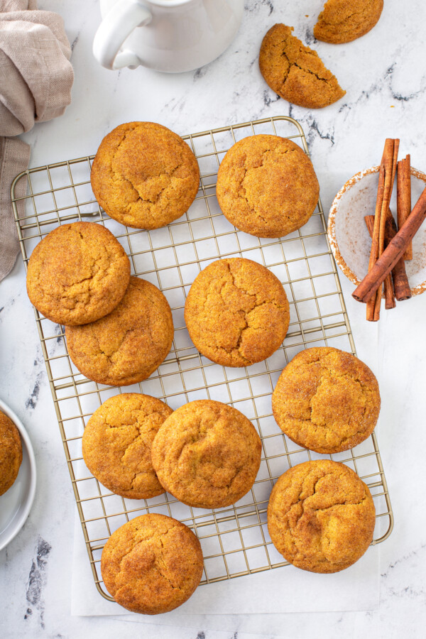 Pumpkin snickerdoodles, coated in sweet cinnamon sugar, are the perfect cookie recipe for fall! These easy pumpkin cookies are so addicting! Pumpkin snickerdoodles on a cooling rack.