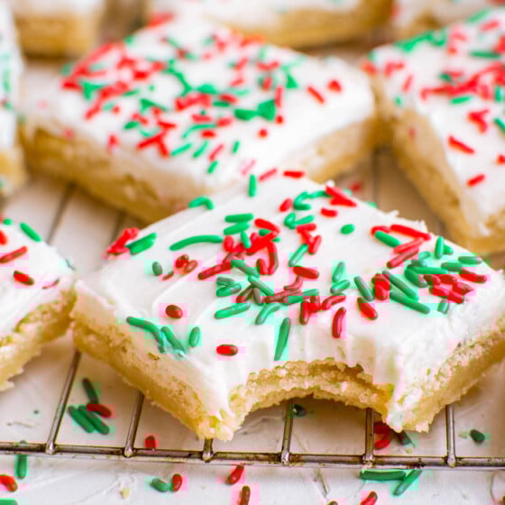 Sugar cookie bar on a cooling rack with a bite taken out of it.