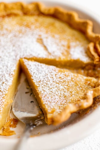 Lifting a slice of pie from a dish.