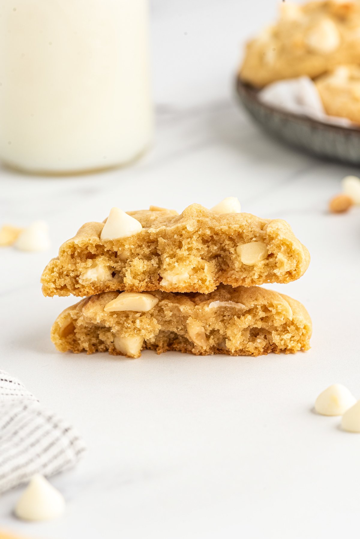Salty-sweet White Chocolate Macadamia Nut Cookies have the perfect balance of chew and crunch. The best white chocolate chip cookies! Side view of a cookie broken in half, to show the texture.